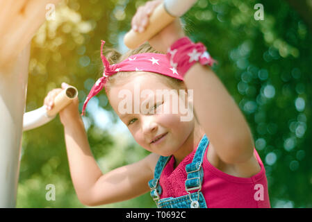 little girl in red bandana pulls up on the simulator. toned Stock Photo