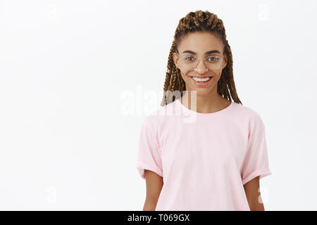 Waist-up shot of attractive stylish and confident young african american girl in trendy glasses with cool dreads smiling pleased meeting customer Stock Photo