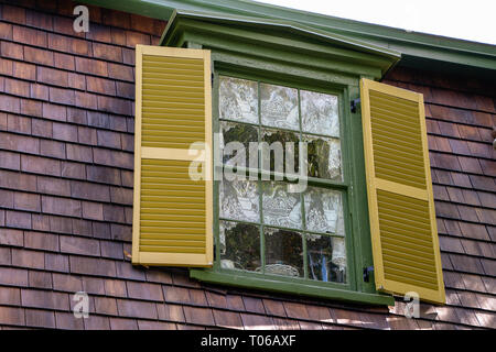 window with gold shutters white lace curtain with cat design Stock Photo