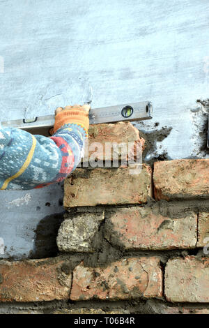 construction mason when laying brick using level tools Stock Photo