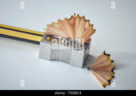Typical yellow and black pencil, sharpener and shavings on white background Stock Photo