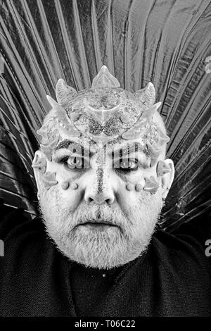 Head with thorns or warts, face covered with glitters, close up. Alien, demon, sorcerer makeup. Senior man with beard, with monster makeup. Fantasy Stock Photo