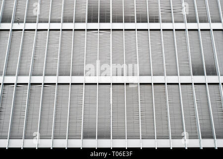 closed sun blinds on office building facade - shutters on building exterior real estate background Stock Photo