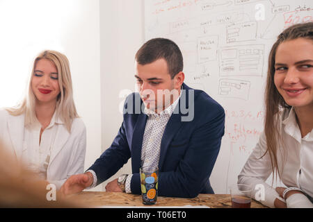 Handsome businessman with his two female architects smiling and discussing a project. Stock Photo