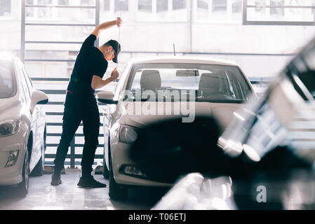 Thief is trying to rob a car with crowbar tool Stock Photo