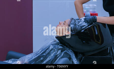 Hairdresser washing hair of woman client Stock Photo