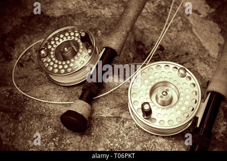 Beautiful Sepia Colored Fly Fishing Rods on a Large Rock Stock Photo