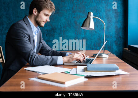 Smiling man in office working on digital tablet. Stock Photo