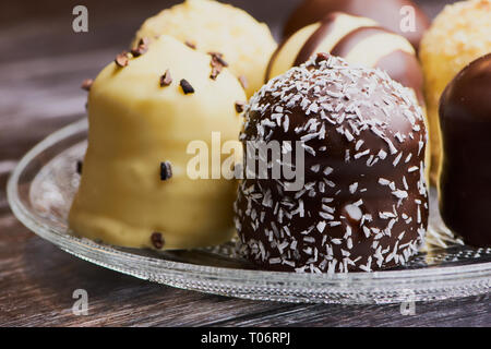 group of white and dark chocolate covered marshmallows on a glass plate, macro color image Stock Photo