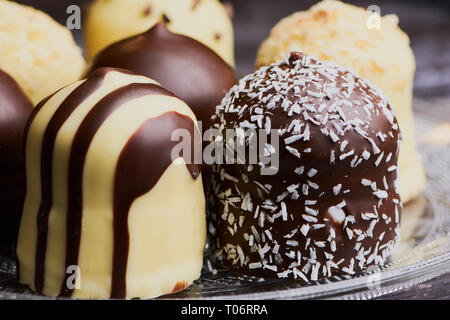 group of white and dark chocolate covered marshmallows on a glass plate, macro color image Stock Photo