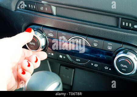 Female hand regulates climate control in car. Studio Photo Stock Photo
