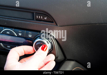 Female hand regulates climate control in car. Studio Photo Stock Photo