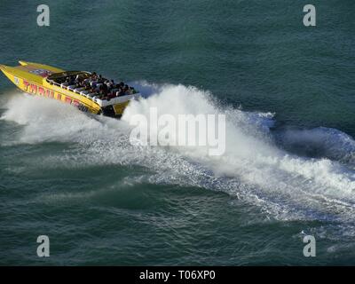 MIAMI, FLORIDA, USA—JANUARY 2018: Wide shot of a tour boat creating huge splashes as it speeds through the waters of Miami coast in Florida. Stock Photo