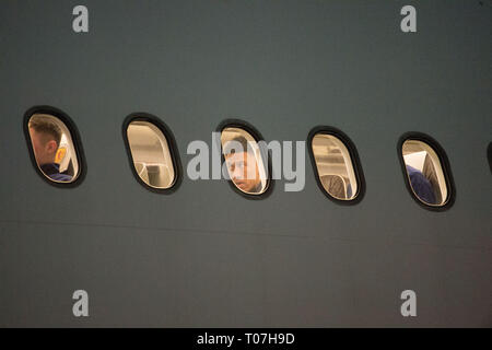Glasgow, UK. 18th Mar, 2019. Liam Palmer (centre window) onboard with the Scotland Football Team seen boarding their luxury jetliner private aircraft in the early hours seen at Glasgow Airport moments before departing for Kazakhstan to play a game on Wednesday. The flight was due to take off at 11pm, however due to an unforeseen problem where the pilot had to come out of the flight deck and onto the tarmac and speak with ground crew, the flight eventually took off in the early hours of today. Credit: Colin Fisher/Alamy Live News Stock Photo