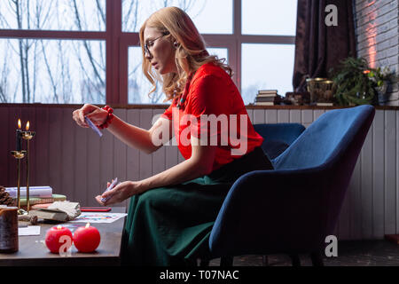 Experienced adult fashionable fortune-teller reading divination cards Stock Photo