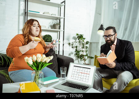 Serious bearded man making notes during consultation Stock Photo