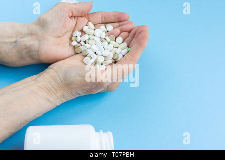 Medicine pills or capsules in elder hand. Stock Photo