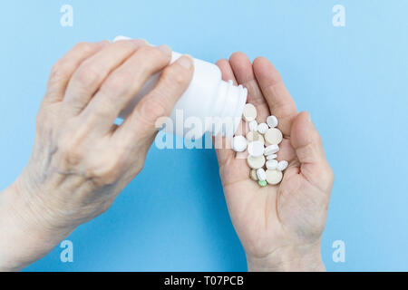 Medicine pills or capsules in elder hand. Stock Photo