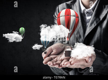 Woman presenting flying balloon in hand. Stock Photo