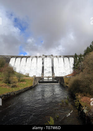 The 56m (184ft) Claerwen dam overflowing after heavy rain in the Elan valley, Powys, Wales, UK. Stock Photo