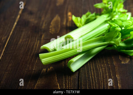 Fresh Celery stalks on dark wooden background Stock Photo