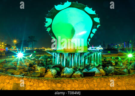Doha, Qatar - February 23, 2019: iconic Oyster and Pearl Monument with fountain on Corniche seaside promenade at beginning of Dhow Harbor illuminated Stock Photo