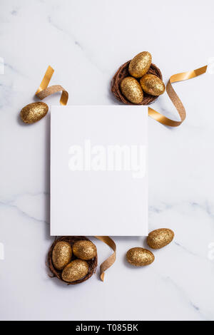 Easter composition. Blank card with gold eggs and nests Stock Photo