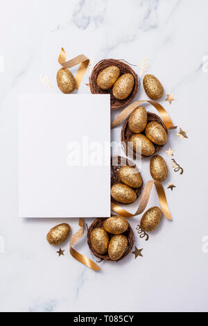 Easter composition. Blank card with gold eggs and nests Stock Photo
