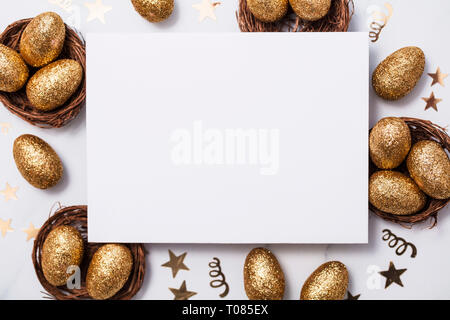 Easter composition. Blank card with gold eggs and nests Stock Photo