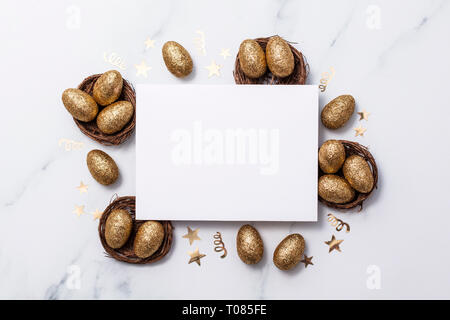 Easter composition. Blank card with gold eggs and nests Stock Photo