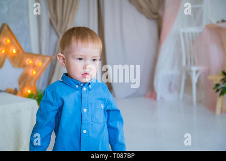 Portrait of little boy staying near bed Stock Photo