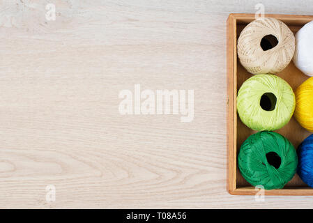 Set of colorful threads for knitting, crocheting in wooden box on the table Stock Photo