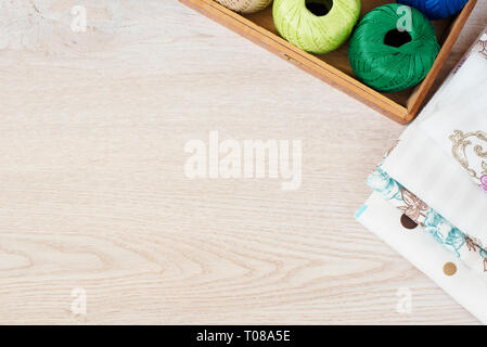 Composition with sewing, knitting threads and fabrics on gray wooden background, top view Stock Photo