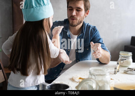 Happy father and daughter having fun while cooking together. Stock Photo