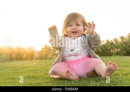 Smiling little cute girl having fun in the grass Stock Photo