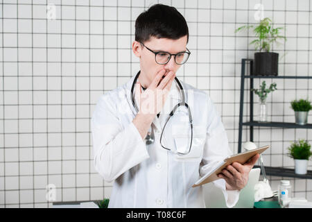 Doctor surprised, shocked from notes on tablet Stock Photo