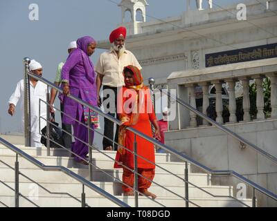 NEW DELHI, INDIA--MARCH 2018: A group of worshipers come down the stairs from the temple of Gurdwara Bangla Sahib at Connaught Place, New Delhi . Stock Photo