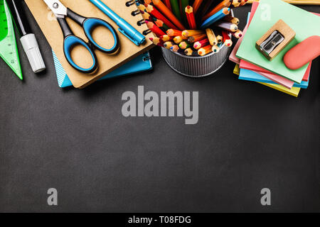 Blackboard with school supplies at the top of the table and copy space, top view Stock Photo