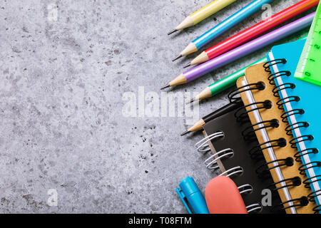 School supplies on the desk with copy space. Top view on pencils and notebooks Stock Photo