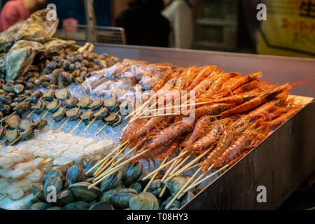 shrimps, oysters, scallops, shellfish and fresh seafood in street food stall in Asian night market Stock Photo