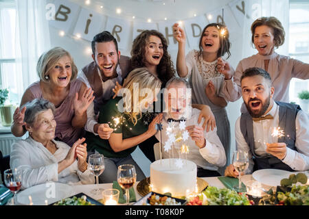 A senior man with multigeneration family celebrating birthday on indoor party. Stock Photo