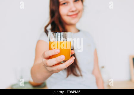 The girl holding glass of orange juice in hand, selective focus Stock Photo