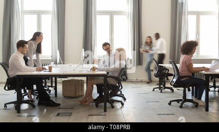 Busy multicultural employees working on computers in modern office rush Stock Photo
