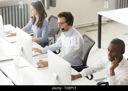 Diverse call center operators team working on computers in office Stock Photo