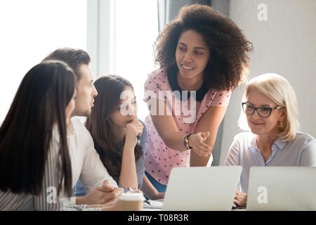 Diverse students workers team and mentor teacher involved in discussion Stock Photo
