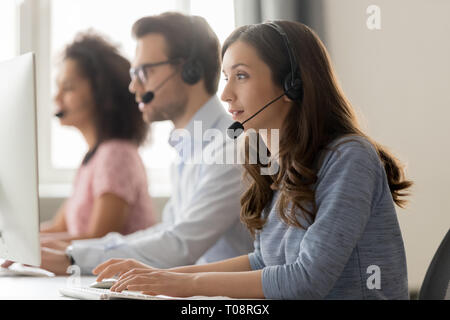 Young woman call center agent in headset consulting online client Stock Photo