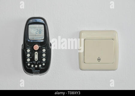 Airconditioner remote control and light switch on white background Stock Photo