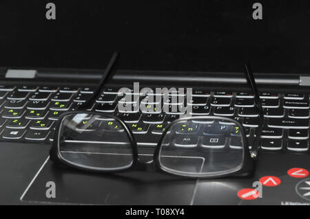 Reading glasses and laptop keyboard Stock Photo