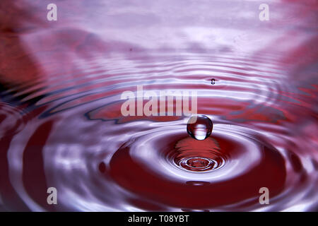 drop in water makes different splashes Stock Photo