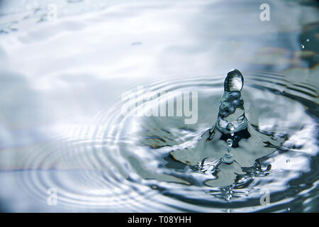 drop in water makes different splashes Stock Photo